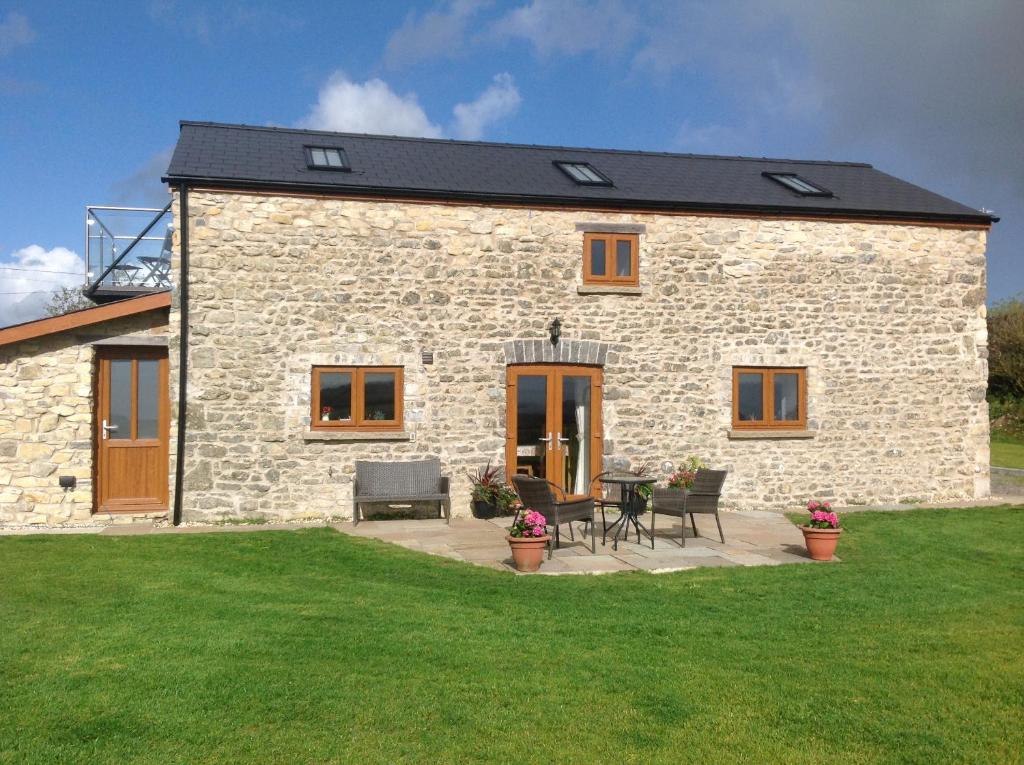 a stone house with a table and chairs in a yard at The Gallops in Cardiff