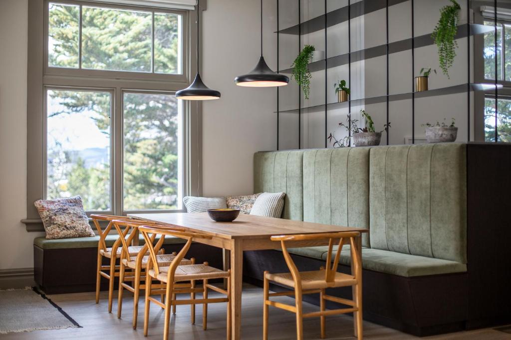 a dining room with a wooden table and chairs at The Burlington Luxury Octagon Apartment in Dunedin