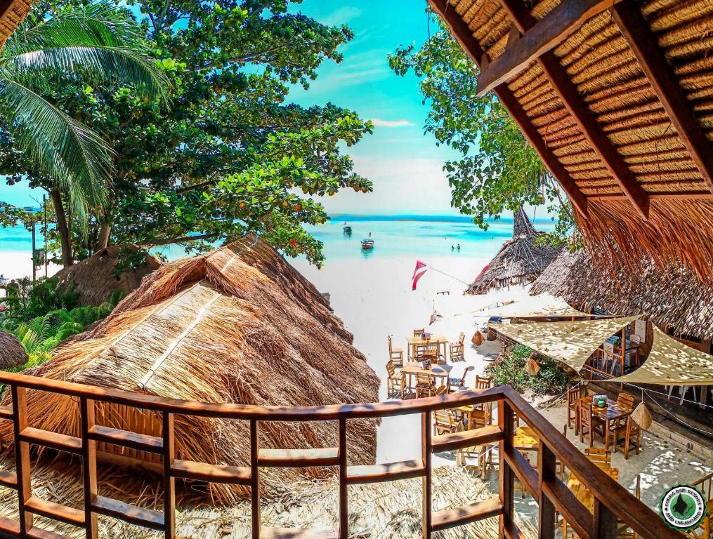 a beach with chairs and umbrellas and the ocean at Forra Pattaya Beach Front Bungalow in Ko Lipe