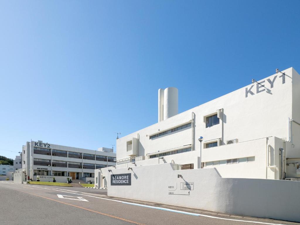 a white building with a kynex sign on it at SEAMORE RESIDENCE in Shirahama