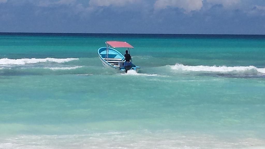 un hombre en un pequeño barco en el océano en Appartamento Cadaques Bayahibe en Bayahibe