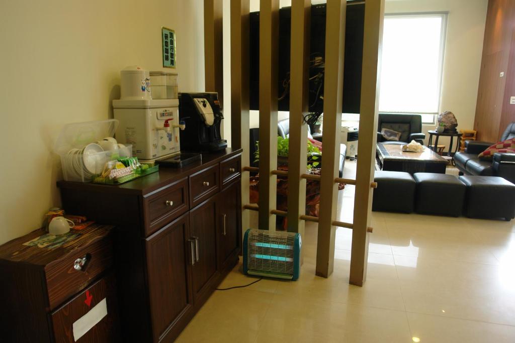 a living room with a kitchen and a living room with a couch at Hualien Sheraton Hostel in Hualien City