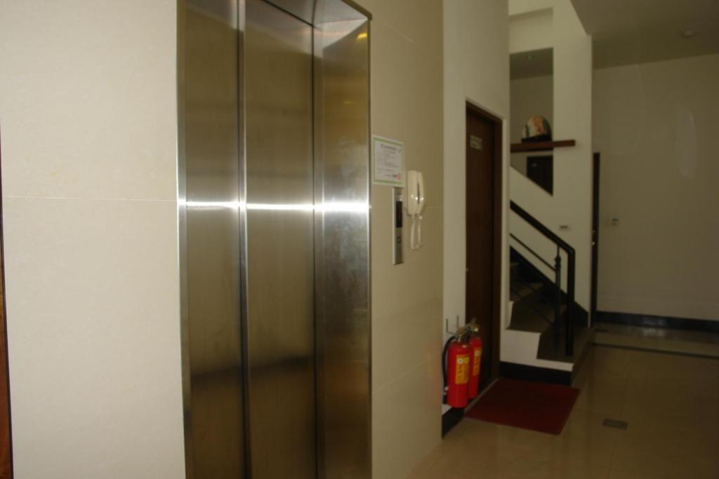 a metal elevator in a room with a fire extinguisher at Hualien Sheraton Hostel in Hualien City