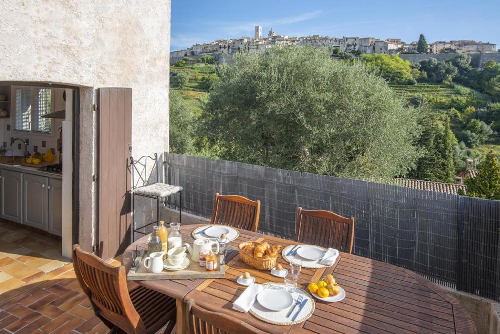 une table en bois avec des assiettes de nourriture sur un balcon dans l'établissement Mas Roseland, à Saint-Paul-de-Vence