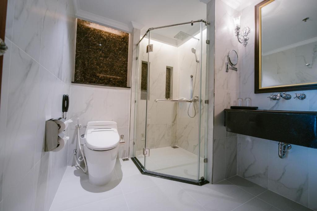 A marble-look bathroom with a glass-enclosed shower and bidet toilet.