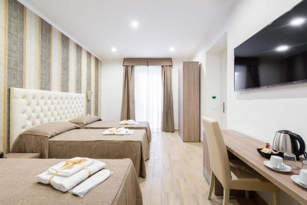 pokój hotelowy z 2 łóżkami i telewizorem w obiekcie chèri luxury suite w Rzymie