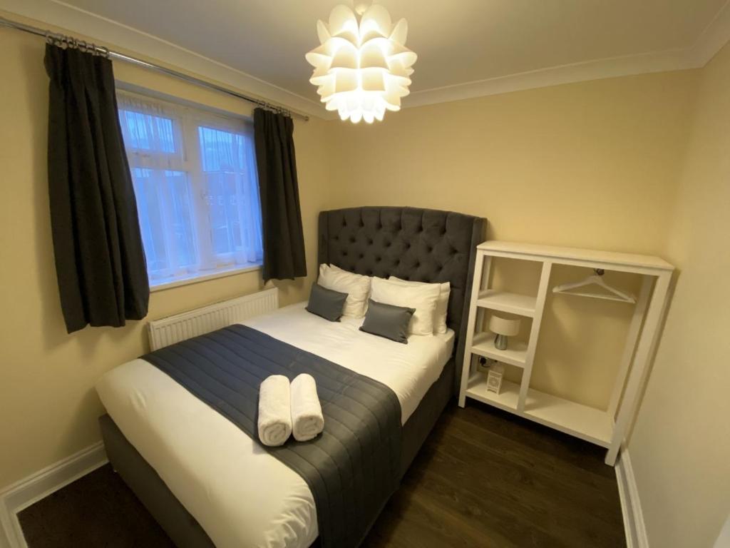 a bedroom with a bed with two white shoes on it at Apartment 20 @ Excel London in London
