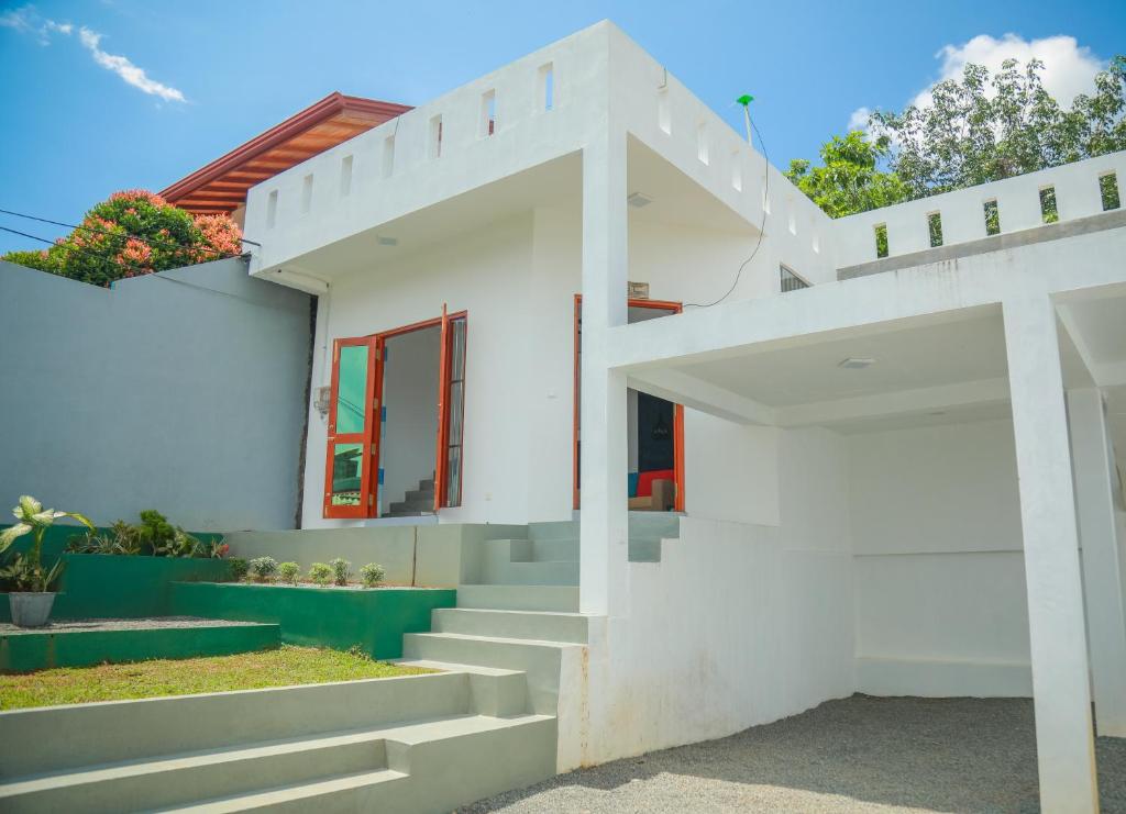 a white house with stairs leading up to it at Blue Berry Villa in Hikkaduwa