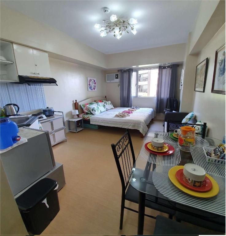 a living room with a bed and a dining room table at Avida Atria Tower 1 Studio Type Condominium in Iloilo City