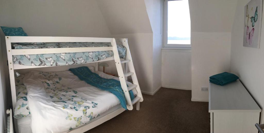 a bunk bed room with two bunk beds and a window at Tigh Na Mara Holiday Home in Aultbea
