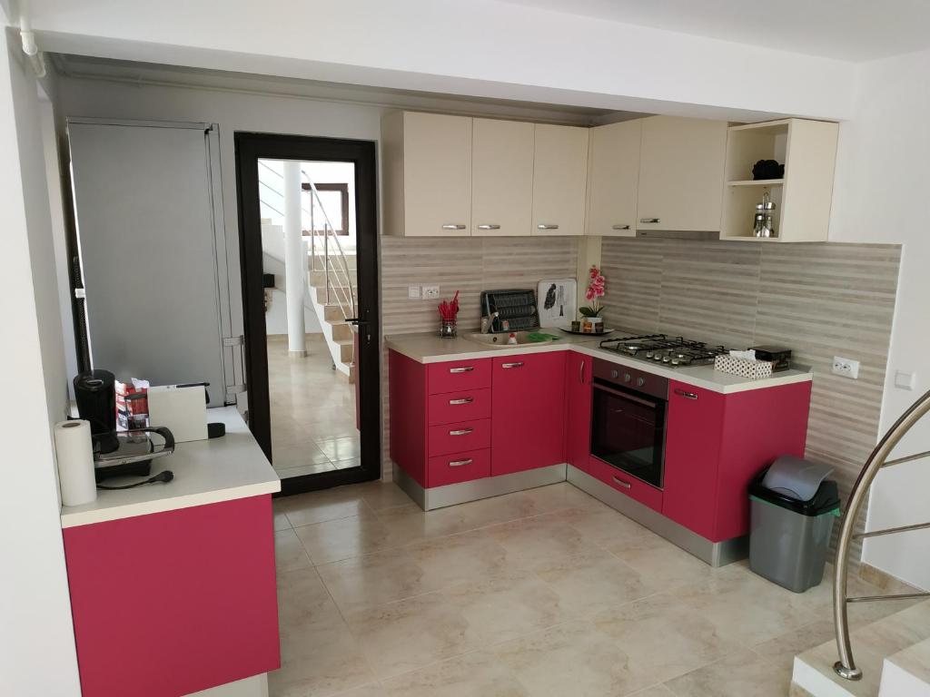 a kitchen with red cabinets and a stove top oven at Entire Home in Bucharest