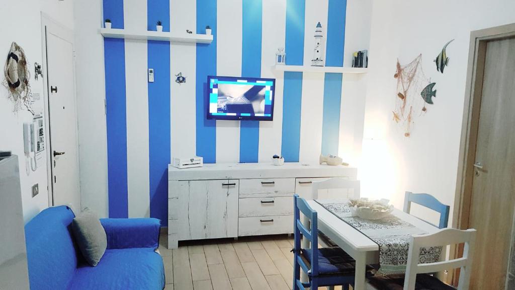 a dining room with a blue and white striped wall at Casa Vacanze Trinacria in Isola delle Femmine