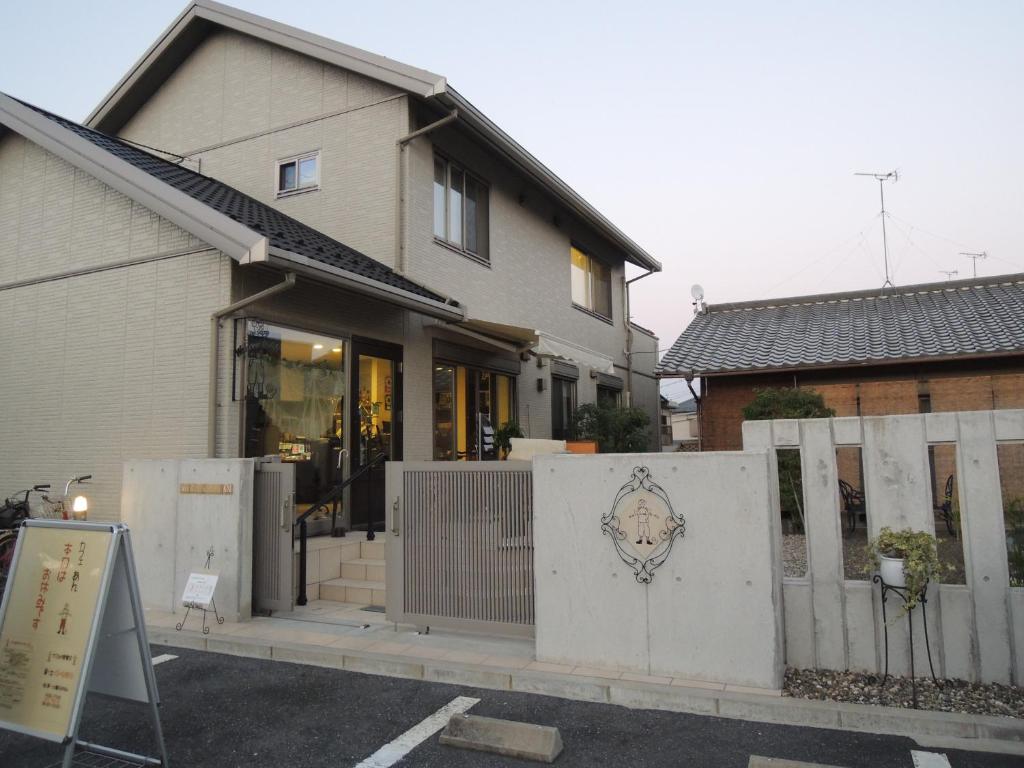 a house with a white fence in front of it at guest house AN in Otsu