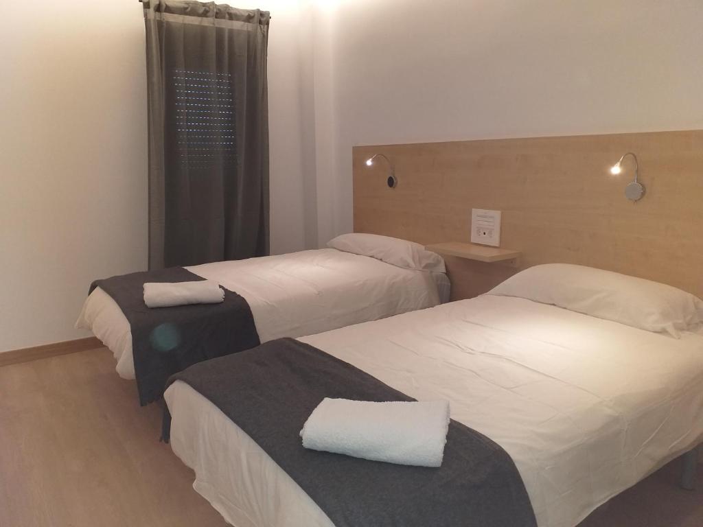 ein Hotelzimmer mit 2 Betten und einem Fenster in der Unterkunft Hotel Casa Marzo in Cariñena