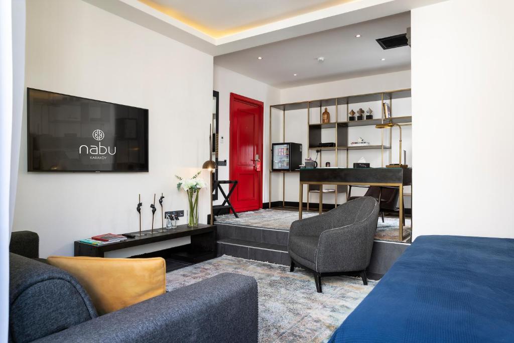 ein Wohnzimmer mit einem Bett und einer roten Tür in der Unterkunft Nabu Hotel Karaköy in Istanbul