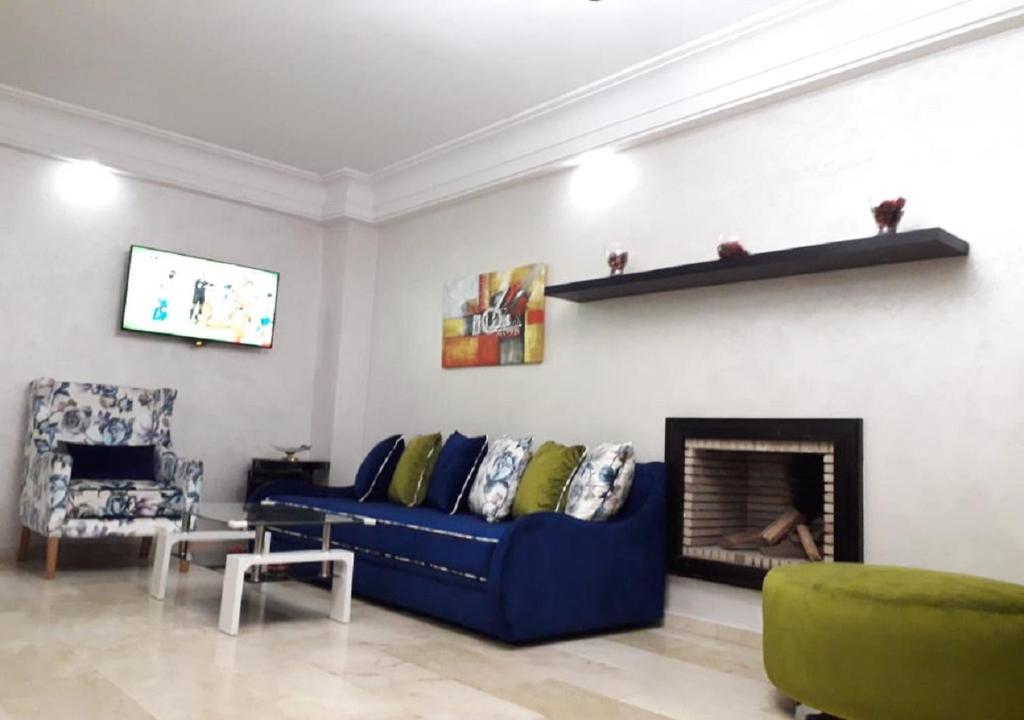 sala de estar con sofá azul y chimenea en Horizon Dream Home, en Casablanca