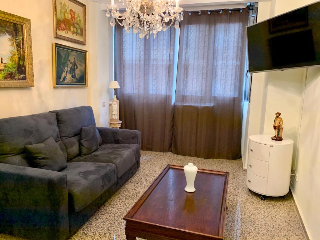 uma sala de estar com um sofá e uma mesa em Apartamentos Torr Av América - López de Hoyos - Chamartín em Madri