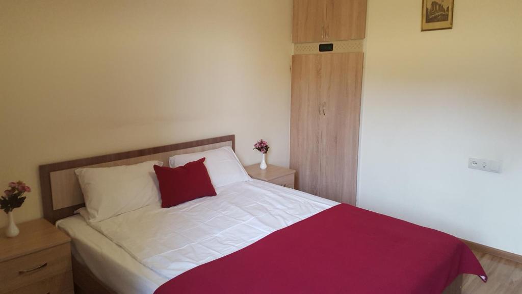 a bedroom with a large bed with a red pillow at Apartment at Republic Square in Yerevan