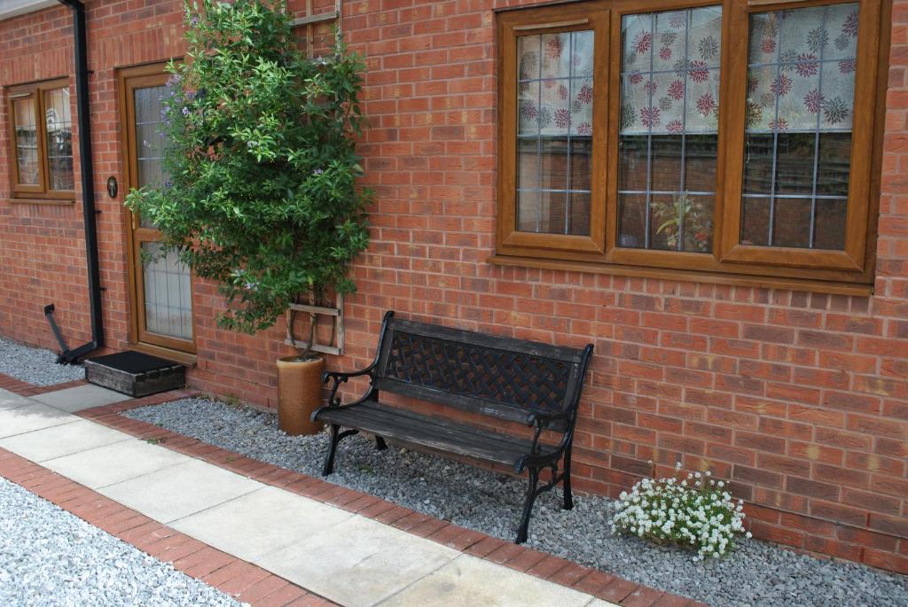 a bench sitting in front of a brick building at Oldcotes Cottages in Firbeck