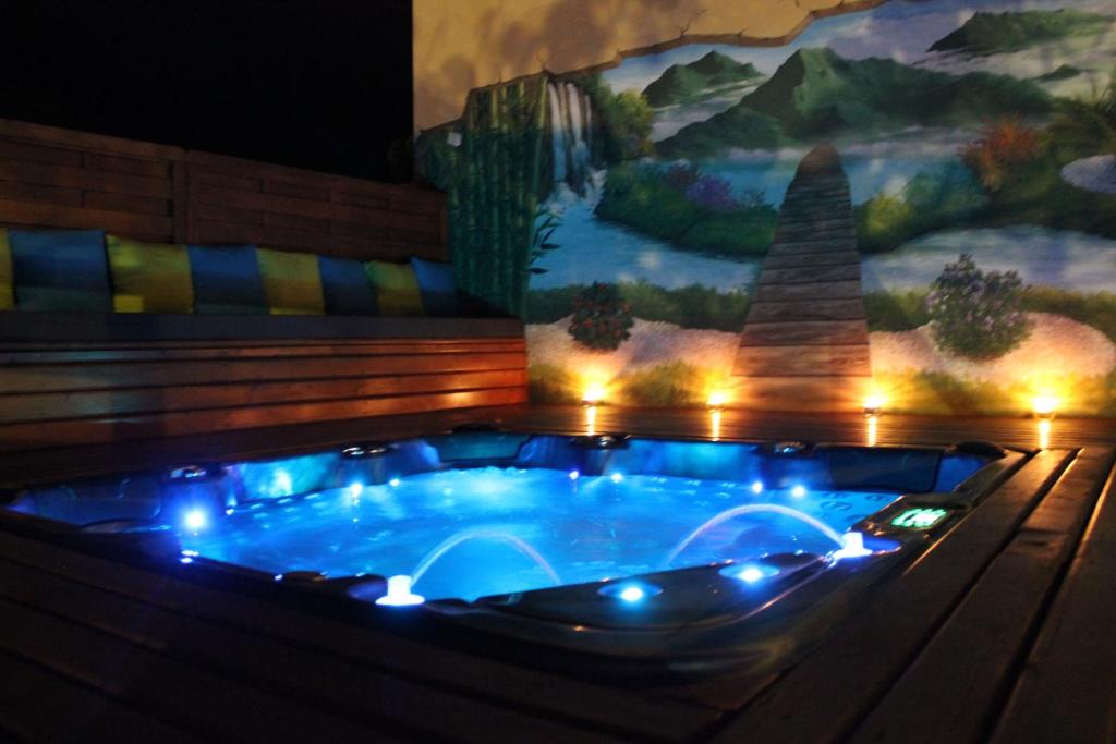 a hot tub with lights in front of a painting at Les 3 Soleils in Saint-Joseph