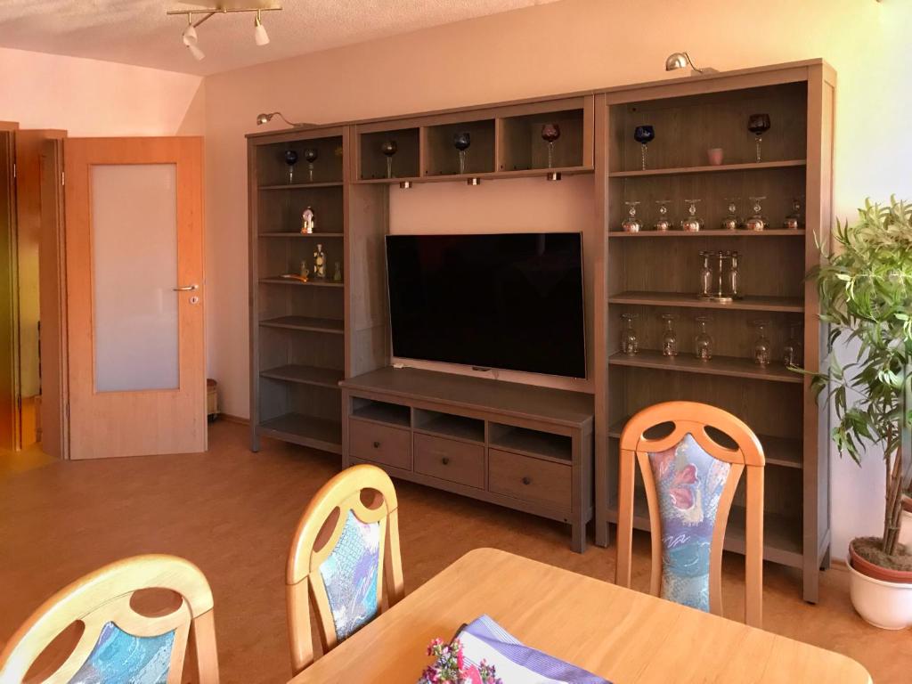 a living room with a television and a table and chairs at Ferienwohnung Burgblick in Betzenstein