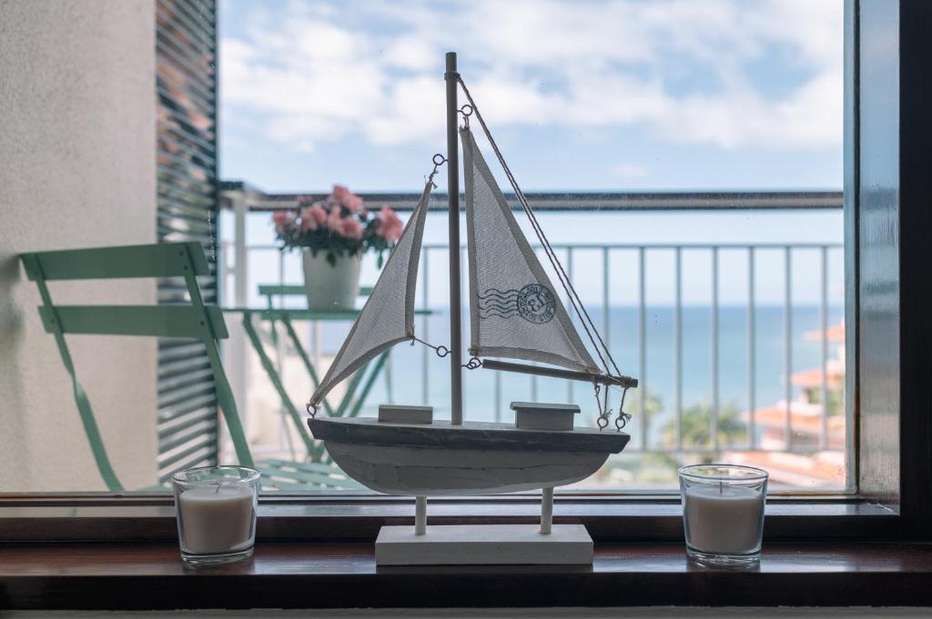 BINIS Apartment في فونشال: وجود قارب ألعاب على طاولة أمام النافذة