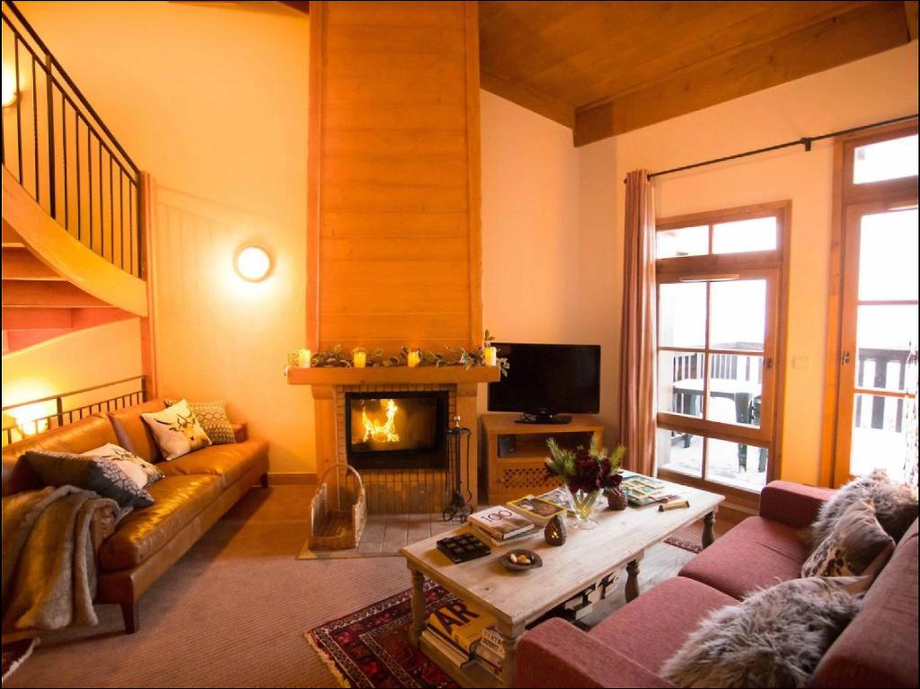 a living room with a couch and a fireplace at Huge Superior 4 Bedroom Apartment, Arc 1950, Les Arc, Spaciously Sleeps 8 to 10 over two floors, Ski In Ski Out in Arc 1950