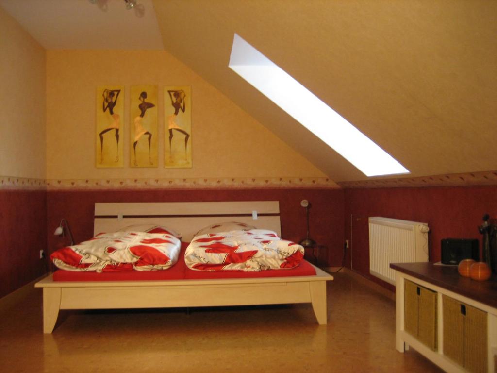 a bedroom with a bed with red and white pillows at Afrikanisches Ambiente in Salzhemmendorf