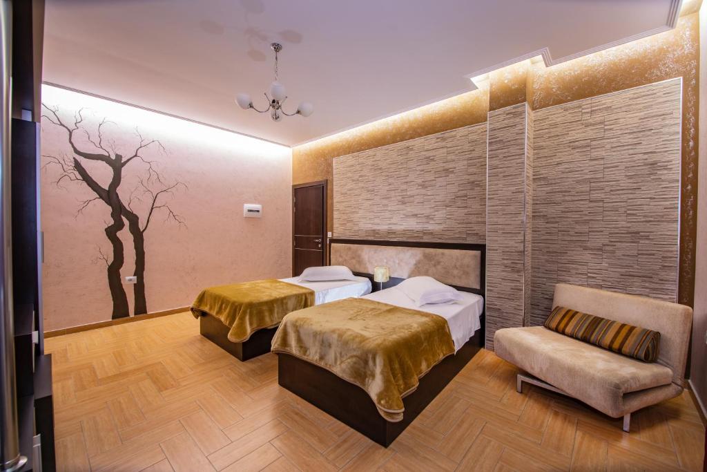 ein Hotelzimmer mit 2 Betten und einem Stuhl in der Unterkunft Fieri International Hotel in Fier