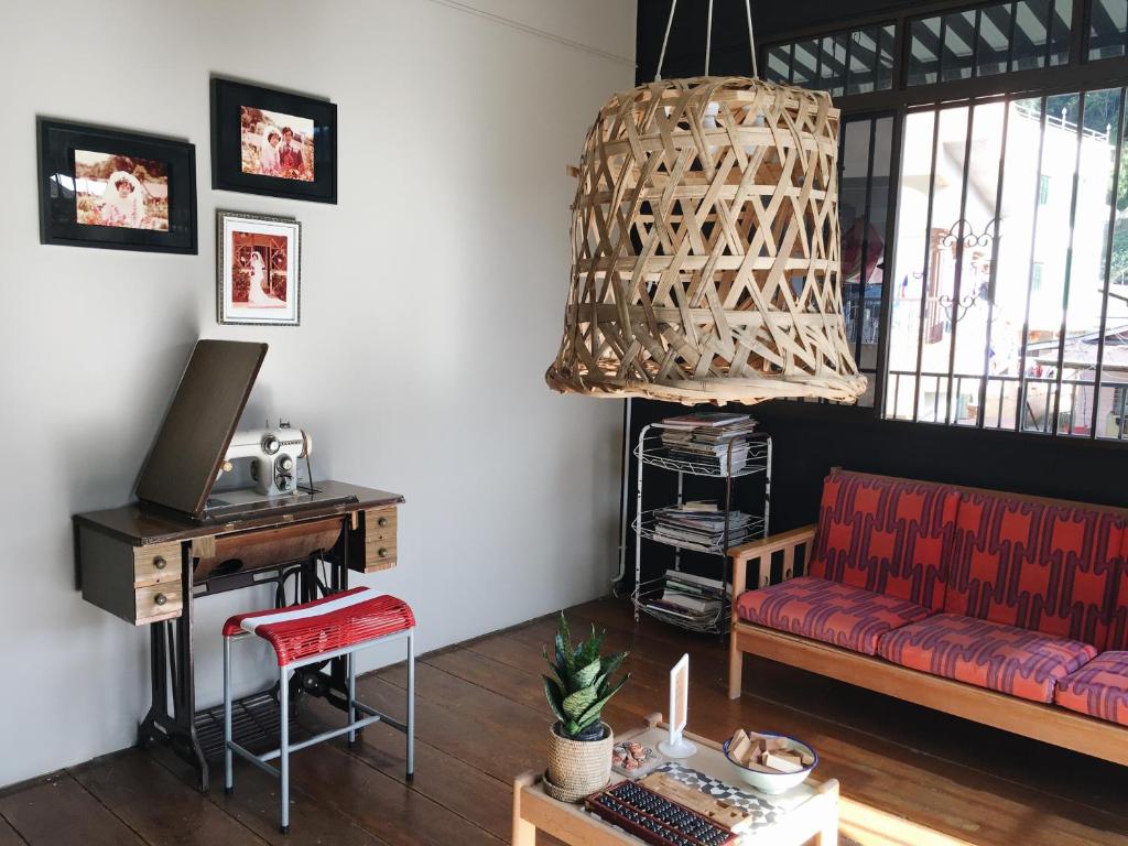 a living room with a red couch and a desk at Wogoxette Upstairs, A Private Kampung Stay In Cameron Highlands in Cameron Highlands