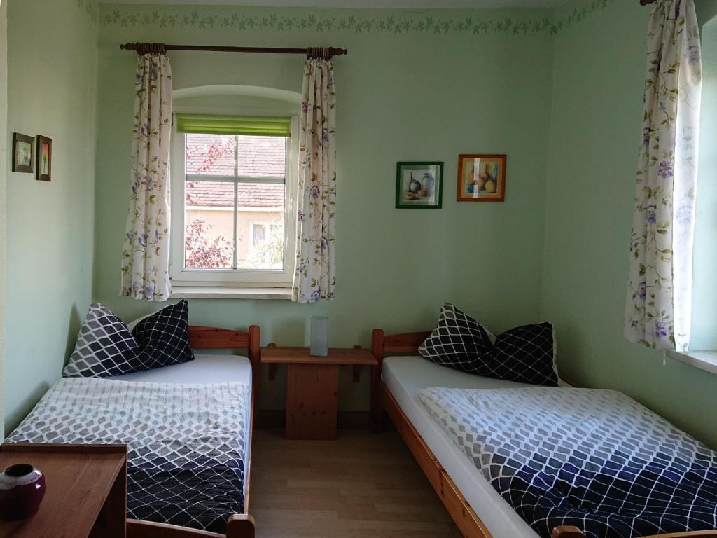 two beds in a room with a window at Alte Käserei Kössern in Grimma