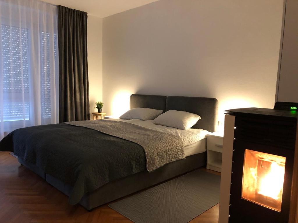 a bedroom with a large bed and a fireplace at Apartman Lana in Gospić