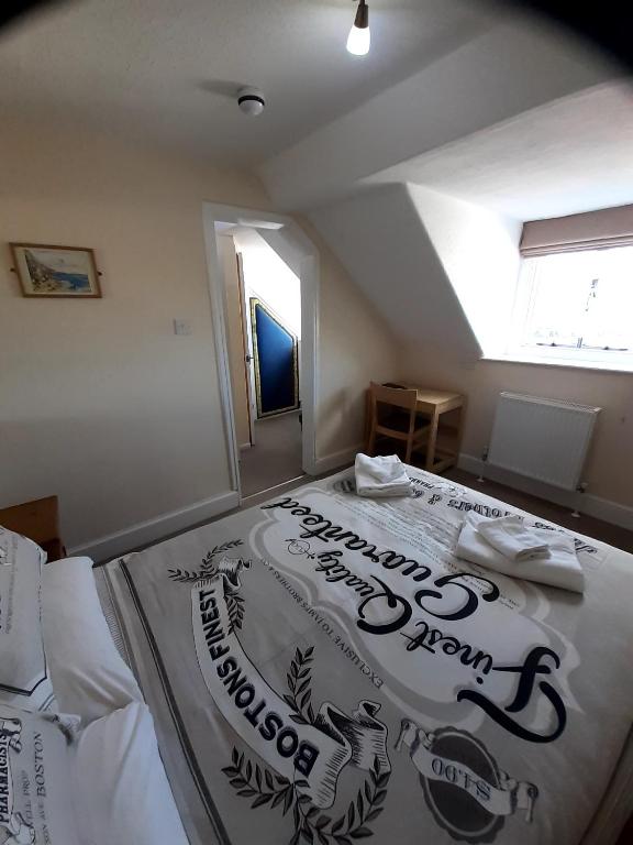 a bedroom with a large bed with a sign on it at The Edenhurst Guesthouse in Weymouth