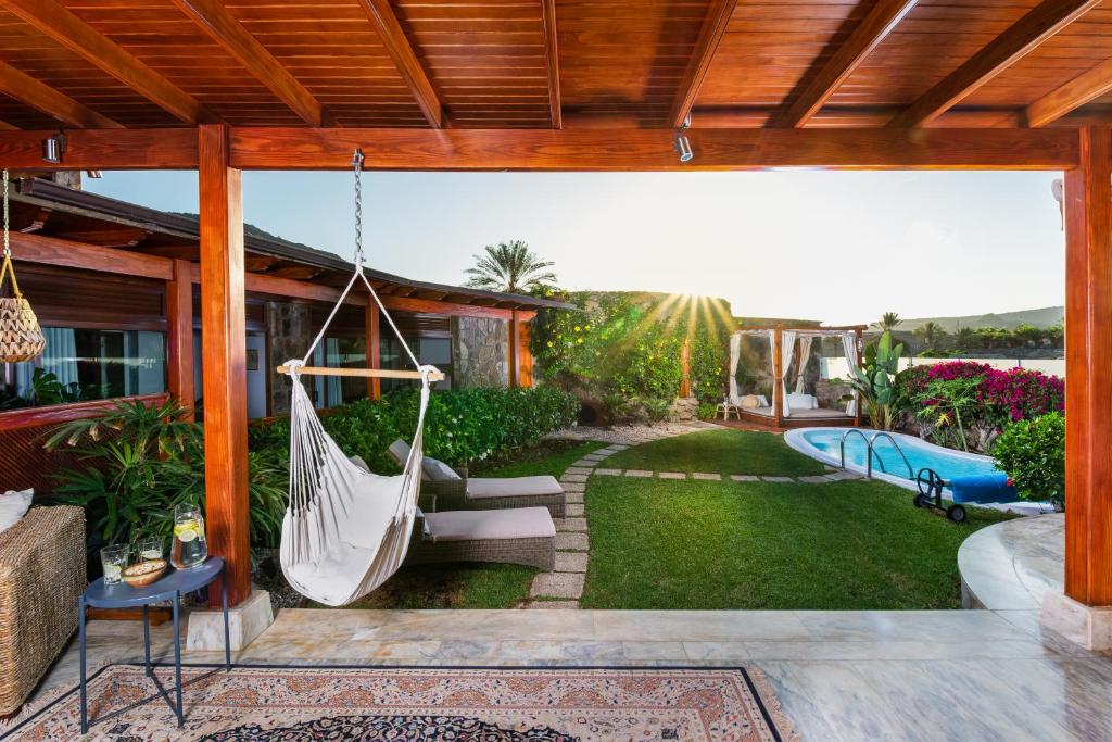 eine Veranda mit Hängematte auf einem Haus in der Unterkunft Gran Tauro Villa in La Playa de Tauro