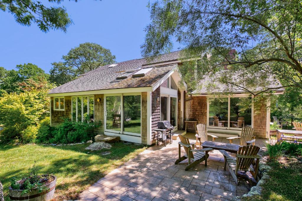 a house with a patio with a table and chairs at Hillside Oak in Chilmark
