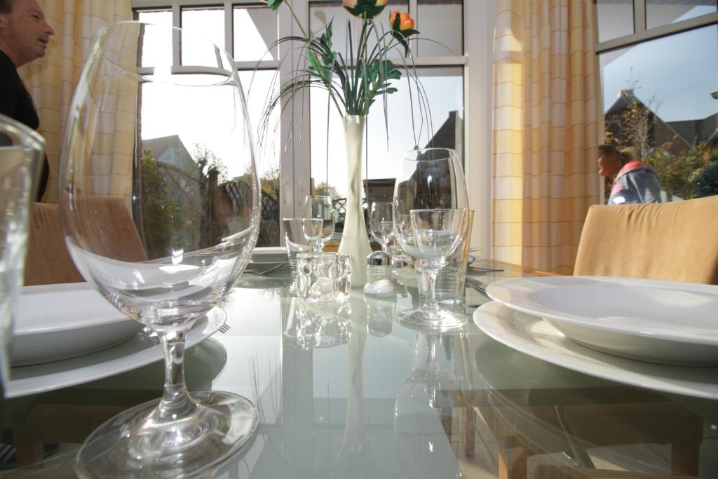 una mesa de cristal con copas de vino encima en Jordsand, en Horumersiel