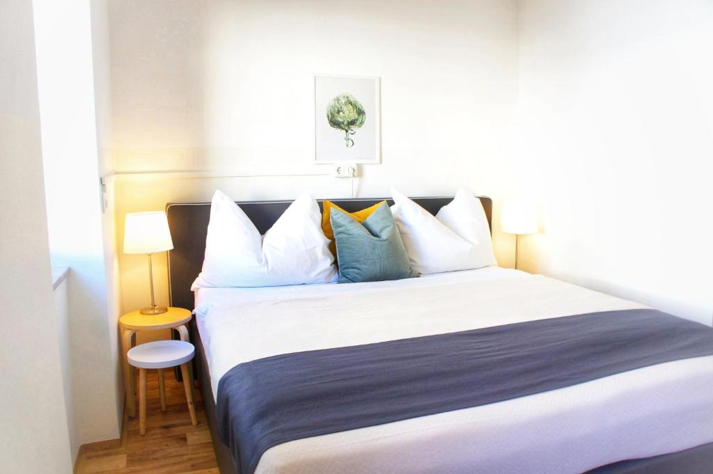 sypialnia z dużym łóżkiem z niebiesko-białymi poduszkami w obiekcie Schwarzacherhof Pension & Apartments w mieście Schwarzach im Pongau