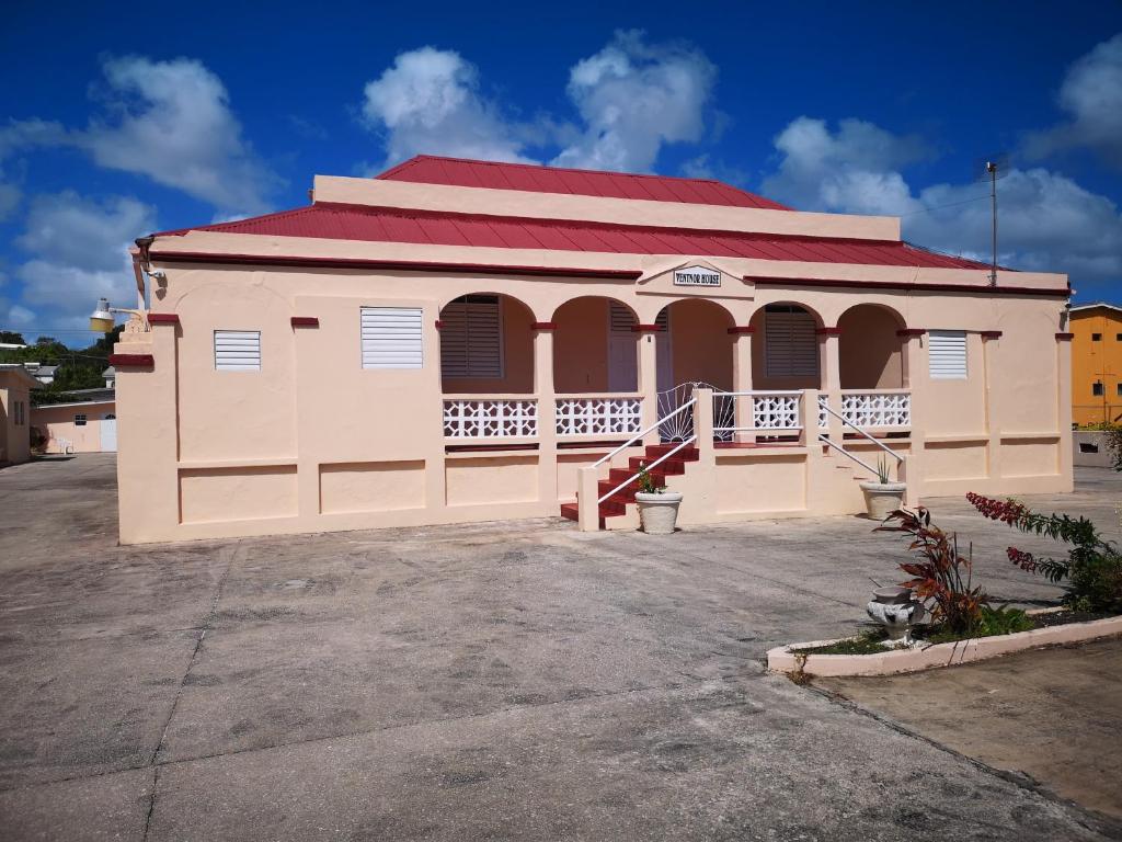 a small building with a red roof and a driveway at Ventnor House Apartments in Bridgetown