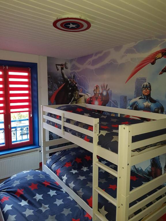 een slaapkamer met een Captain America muurschildering aan de muur bij Iliade in Rue