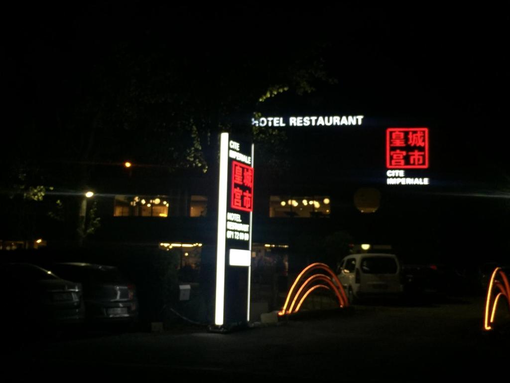 a sign for a gas station at night at cité impériale ye in Mettet