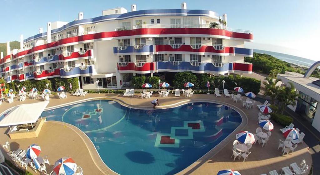 un gran hotel con piscina frente a un edificio en Apartamento de 1 quarto de frente a praia dos Ingleses, en Florianópolis