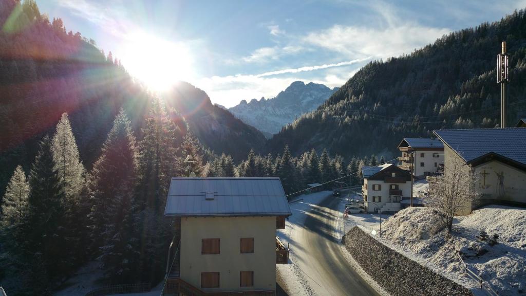 a snow covered mountain with the sun in the sky at Digonera Historic Hotel B&B in Rocca Pietore