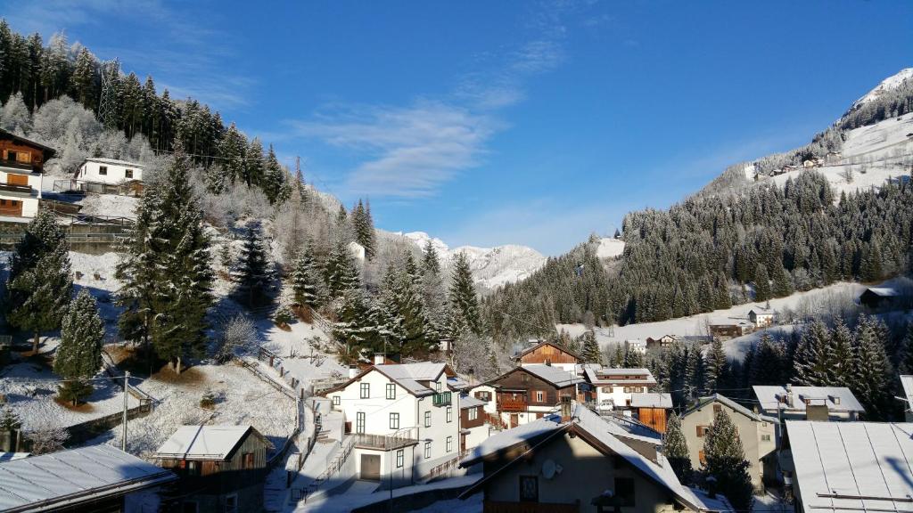 a village in the mountains with snow on the ground at Digonera Historic Hotel B&B in Rocca Pietore