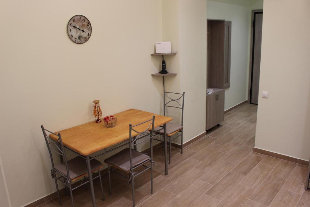 tavolo e sedie in una stanza con orologio sul muro di Comfortable apartment in the center of Athens ad Atene
