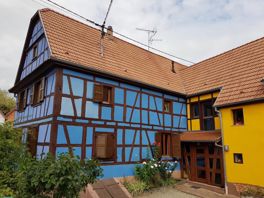 un edificio amarillo y azul con techo marrón en maisonbleue67 en Kurtzenhouse
