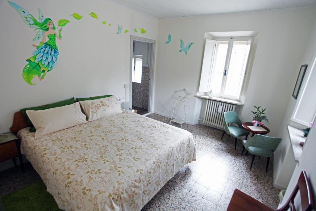 um quarto com uma cama, uma cadeira e janelas em Casa Cristallo em Gesso