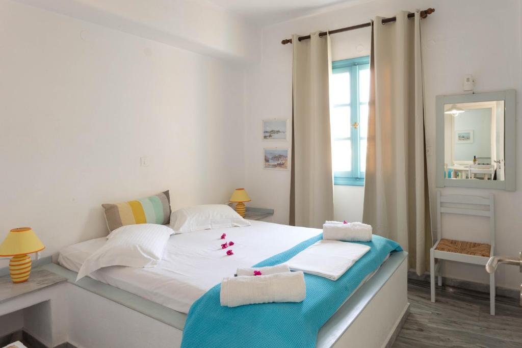 Un dormitorio con una cama blanca con toallas. en Ragousis Apartments, en Parikia