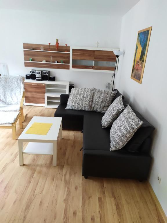 a living room with a black couch and a table at Apartament Irek 1000L PP in Międzyzdroje
