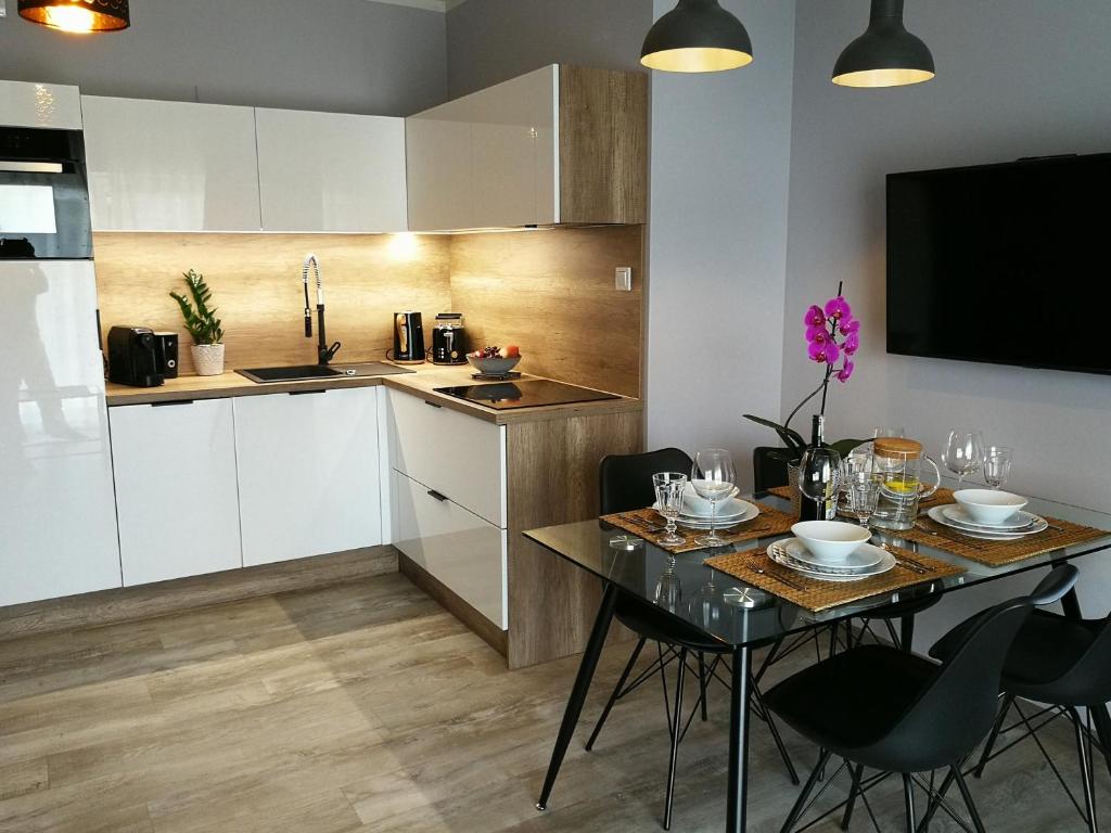 a kitchen and dining room with a table and chairs at Coral SPA Apartament Pięć Mórz in Sianozety