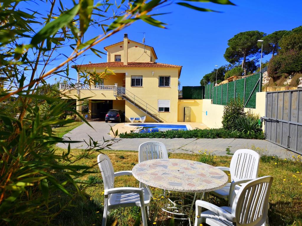 a table and chairs in front of a house at Villa Fradera in Lloret de Mar